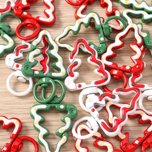 Detail of Christmas tree shaped metal lobster clasps with festive enamel patterns
