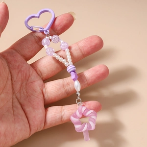 Detail eines handgefertigten Perlen-Schlüsselanhängers mit lila Herzclip und Sternperlen