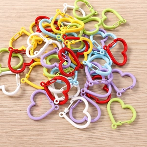 Close-up of colorful heart-shaped spring buckles in six vibrant colors on wood background