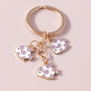 Detail view of cartoon fish keychains with purple spotted enamel and gold rings