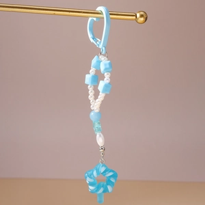 Detail eines hellblauen Perlen-Schlüsselanhängers mit Lollipop-Charm und Herzverschluss
