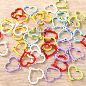 Macro shot of assorted candy-colored heart-shaped carabiner keychains on wood