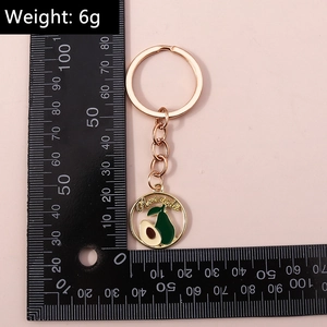 Vue détaillée du porte-clés avocat avec anneau doré rose et mesure du poids de 6g