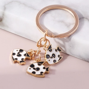Golden fish keychain featuring three white and black spotted fish charms for bags