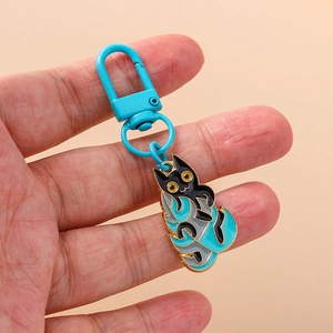 Porte-clés créatif en émail chat noir avec yeux jaunes et motifs de nuages bleus