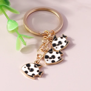 Macro detail of gold-plated tropical fish charms with black polka dots and shiny chain