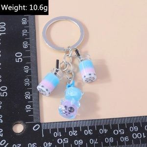 Detailed view of bubble tea charms and bear keychain with scale showing 10.6g weight
