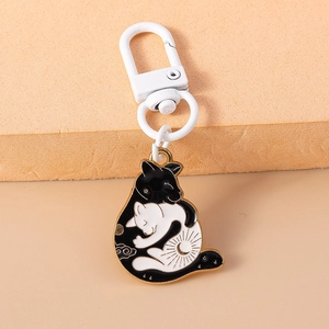 Détail du porte-clés émaillé chat yin-yang avec fermoir blanc et motifs de nuages dorés