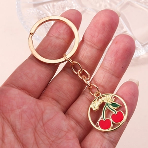 Porte-clés doré avec pendentif rond en émail cerise et lettrage artistique Cherry