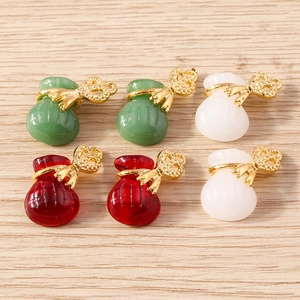 Detail shot of colorful resin lucky bag pendants with golden bow knots for DIY jewelry