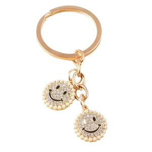 Golden keychain featuring sparkling rhinestone smiley face pendants with elegant white pearls