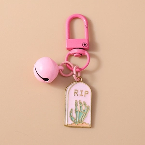 Détail du porte-clés rose avec pendentif tombeau RIP, main de squelette et clochette rose