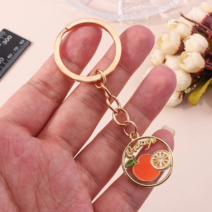 Porte-clés doré avec un pendentif rond en émail d'orange et inscription Orange