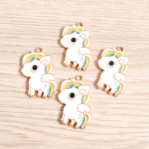 Detailed view of four colorful unicorn enamel pendants with gold-plated metal borders