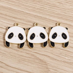 Dettaglio di tre ciondoli a forma di panda bianco e nero con bordo dorato per gioielli