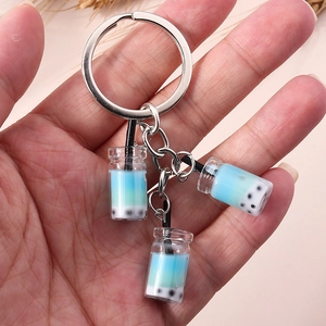 Detail von drei kreativen Mini-Bubble-Tea-Schlüsselanhängern mit blauen Resin-Bechern