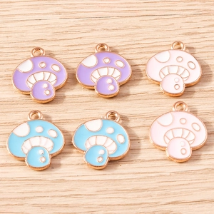Flat lay of colorful mushroom charms in purple, pink, and blue for DIY jewelry