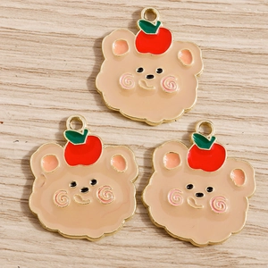 Dettaglio di ciondoli a forma di orso con mela rossa per creazione di gioielli e accessori