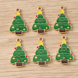 Detail of green enamel Christmas tree pendants with gold frames for DIY jewelry making