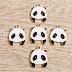 Dettaglio di cinque ciondoli a forma di panda in smalto con bordi dorati per gioielli