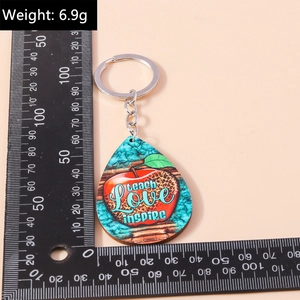 Detail of wooden teardrop keychain with teacher theme and size measurement on wood ruler