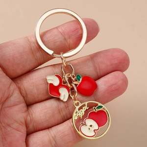 Fashionable red apple keychain with gold alloy wings and artistic lettering bag charm