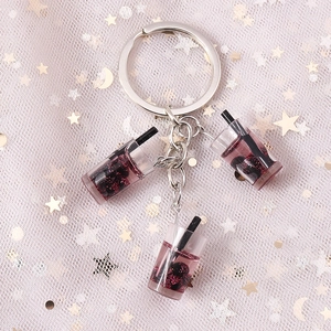 Detailansicht von rosa Milchtee-Schlüsselanhängern mit Glitzer und Perlen auf Tüllnetz