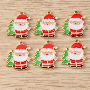 Detail of six Santa Claus pendants with green trees on rustic wood background