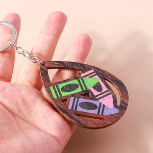 Detail showing hand-held wooden teardrop keychain with colorful crayon art insert