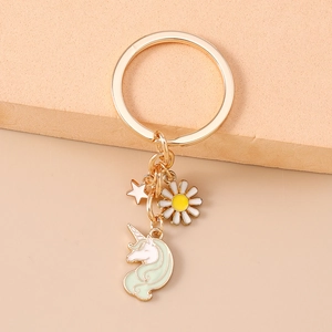 Detail eines goldenen Schlüsselanhängers mit Gänseblümchen, Stern und Einhorn-Anhänger