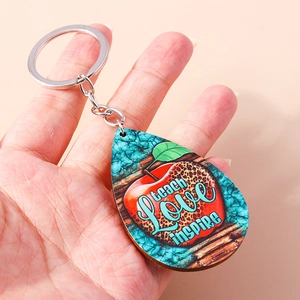 Teardrop wooden keychain with apple design and Teach Love Inspire text for teacher gifts