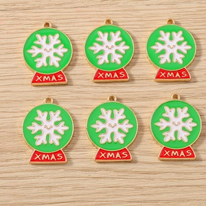 Detail view of 6 enamel Christmas snow globe charms with XMAS lettering on wood