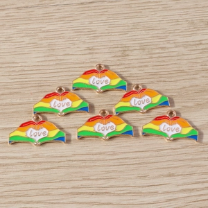 Détail de 6 pendentifs cœur arc-en-ciel love sur un fond en bois clair naturel