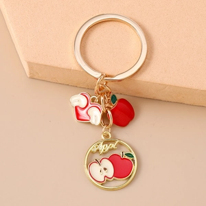 Detailed close-up of apple fruit keychain with red heart and polished gold ring