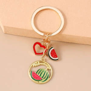 Detail of watermelon themed keychain with red heart and gold plated fruit charms