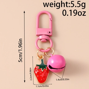Detailed view of pink strawberry charm with dimensions, bell, and golden clasp keychain