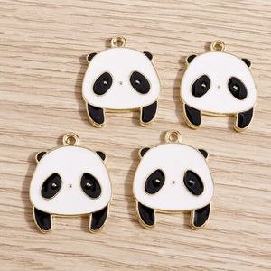 Dettaglio di quattro ciondoli panda in smalto bianco e nero con cornici in lega dorata