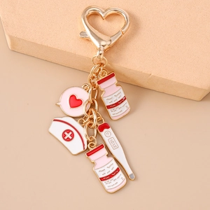 Detail of medical nurse keychain featuring golden heart, thermometer and enamel nurse cap