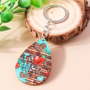 Detail of teardrop wooden teacher keychain with apple and leopard print heart design