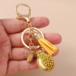 Porte-clés durian à la main avec fermoir doré en métal et gland décoratif jaune