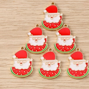 Detailed view of six Santa and watermelon charms on a light wood background for DIY