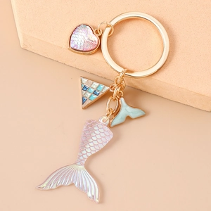 Detail view of mermaid tail keychain with iridescent coating and golden metal ring