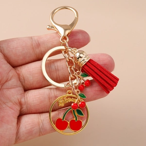 Porte-clés cerise doré avec pompon rouge et breloques de cerise polies pour sacs à main