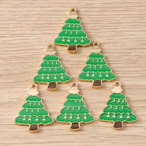 Detailed macro view of green enamel Christmas tree charms with gold plating and stars