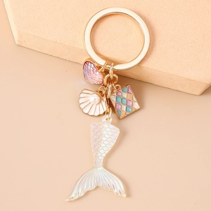Detail of iridescent mermaid tail keychain with pearl shell and colorful charms