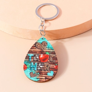 Detailed view of teardrop wooden keychain with leopard heart and teacher text design