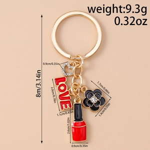 Detailed view of golden keychain with red lipstick, black flower, and LOVE charms
