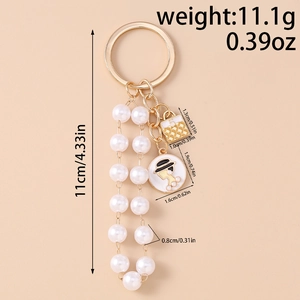 Detail view of pearl tassels and vintage female portrait pendant on gold keychain