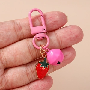 Pink strawberry bell keychain with metallic red fruit charm and D-shaped ring clip