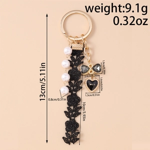 Detail view of fashion keychain with pearl strand, black lace flower, and love heart charm